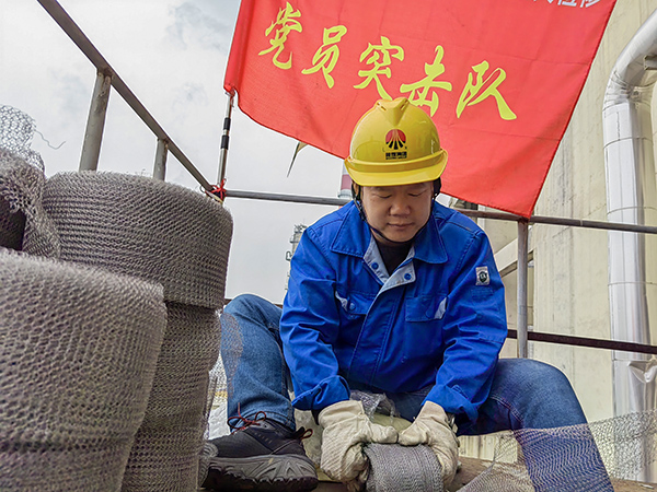 5月10日中午，在動力車間三期工藝除氧器平臺上，黨員突擊隊隊長李鑫正在纏繞新填料.jpg