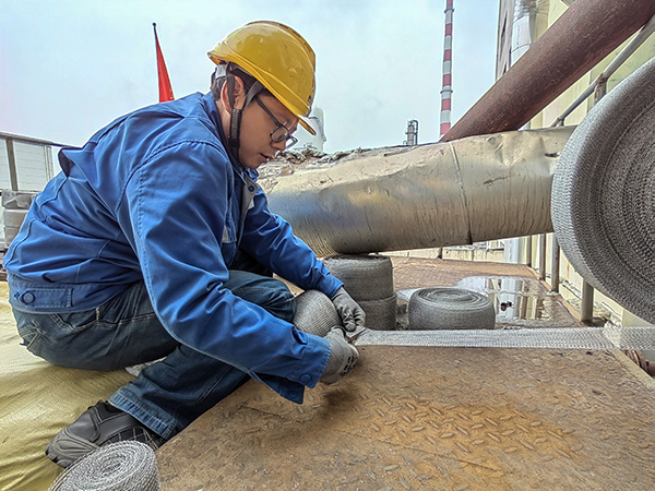 5月10日中午，在動力車間三期工藝除氧器平臺上，黨員突擊隊隊員劉瑞斌正在纏繞新填料.jpg