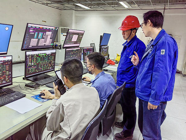 5月13日，動力車間三期鍋爐控制室，DCS改造工藝、儀表、電氣等部門聯(lián)合調(diào)試，車間主任姜軍虎與技術員畢加佳查看調(diào)試過程.jpg