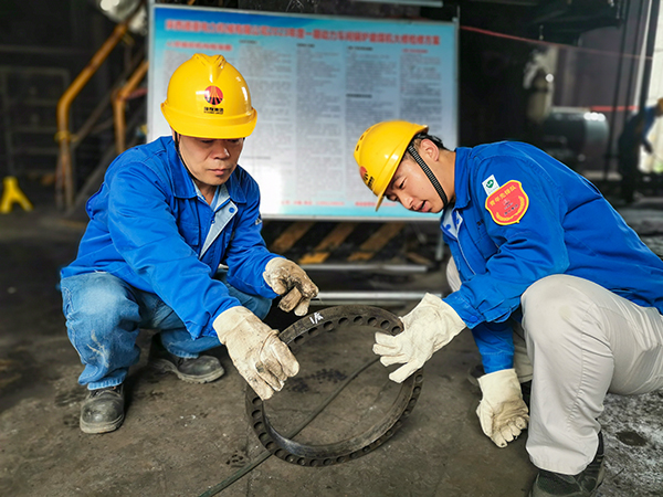 圖三：12日下午14時，在一期磨煤機(jī)廠房，陜西省技術(shù)能手姬霄給青工張跟潮講解磨煤機(jī)搖臂曲拐內(nèi)環(huán)及動作原理。.jpg